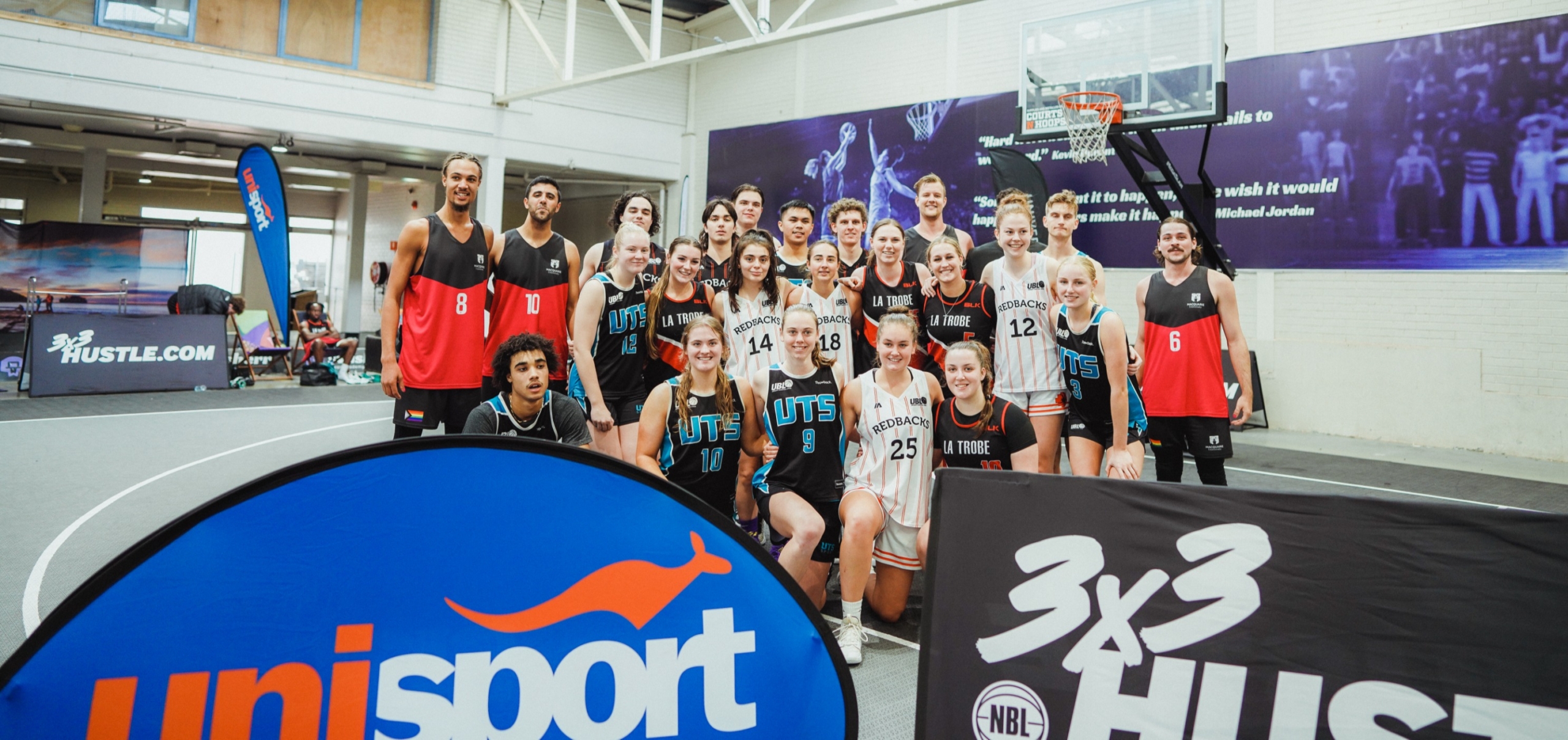 Large group of The University of Sydney students gathered posing with 'champions' banner at Nationals Athletics competition.