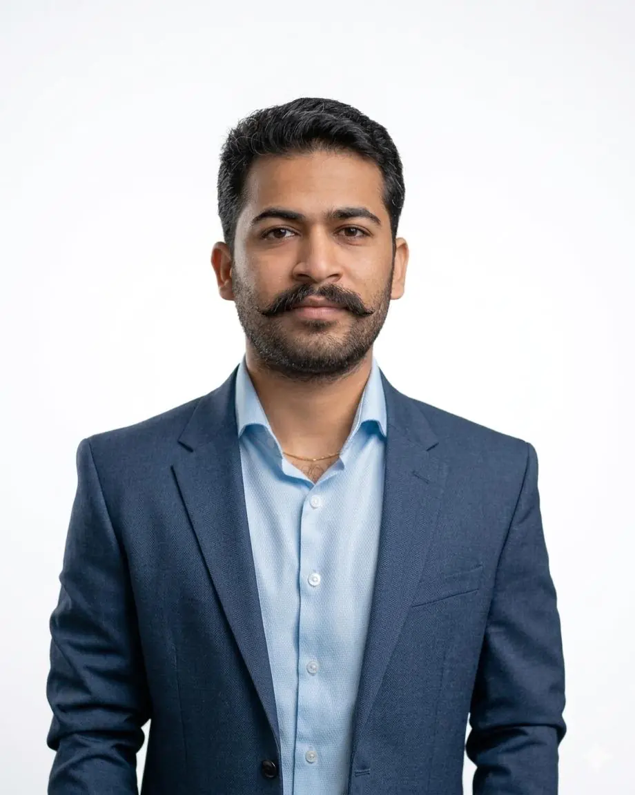 Professional headshot of a man in a blue suit and light blue shirt against a white background.