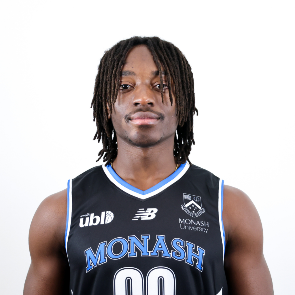 Portrait of a Black basketball player wearing a Monash University jersey, facing camera with a neutral expression.