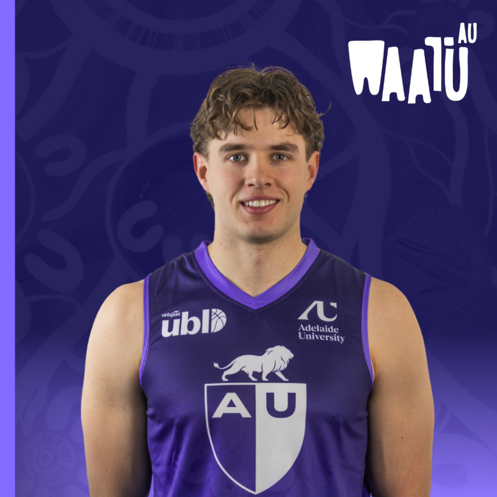Young male athlete in a purple AU jersey standing against a purple backdrop with AU logos.
